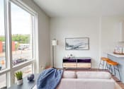 Thumbnail 24 of 54 - A modern living room with a grey couch and a blue blanket on it. at The Arlow on Kellog, St. Paul, 55102