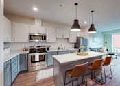 Thumbnail 7 of 54 - A modern kitchen with a large island and chairs. at The Arlow on Kellog, St. Paul, MN, 55102