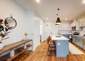 Thumbnail 8 of 54 - A modern kitchen with a blue island and stainless steel appliances. at The Arlow on Kellog, Minnesota