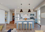 Thumbnail 1 of 54 - A modern kitchen with a bar stool and a dining table. at The Arlow on Kellog, Minnesota