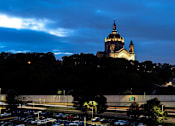 Thumbnail 54 of 54 - A large white building with a golden dome is lit up at night.