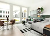 Thumbnail 7 of 19 - A modern bedroom with a large bed and a dining table with chairs.