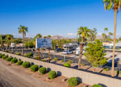 Thumbnail 24 of 26 - a parking lot with palm trees and a sign that says desert trail rv resort