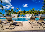Thumbnail 28 of 34 - a swimming pool with chairs and a blue sky at Magnolia Square, Naples, 34109