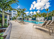 Thumbnail 27 of 34 - pool surrounded by palm trees and brown pool chairs at Magnolia Square, Naples