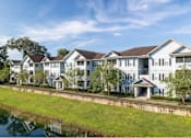 Thumbnail 24 of 26 - a large apartment complex with a grassy area in front of it at Magnolia Village Apartments, Jacksonville, FL, 32207