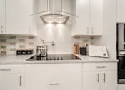 Thumbnail 3 of 34 - a kitchen with white cabinets and a quartz countertop at Magnolia Square, Naples, 34109