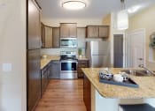 Thumbnail 2 of 49 - a kitchen with wooden cabinets and stainless steel appliances at Skye at Arbor Lakes, Maple Grove, Minnesota