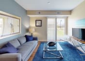 Thumbnail 8 of 49 - a living room with a gray couch and a blue rug at Skye at Arbor Lakes, Maple Grove, 55369