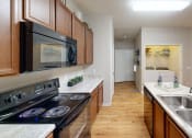 Thumbnail 6 of 44 - a kitchen with wood cabinets and white countertops