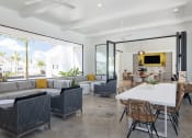 Thumbnail 32 of 40 - Open concept resident space with a white dining table and rattan chairs at Odyssey, Florida