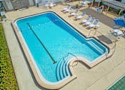 Thumbnail 6 of 12 - A large outdoor swimming pool with a blue tinted water.