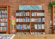 Thumbnail 10 of 12 - A room with a bookshelf and a sign that says "Fun Times Pines Sunny".