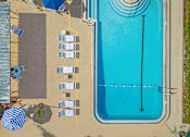 Thumbnail 5 of 12 - A large blue swimming pool with a diving board and lounge chairs.