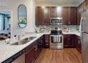 Thumbnail 1 of 39 - a kitchen with dark wood cabinets and stainless steel appliances at The Bend Arbordale, Williamsburg