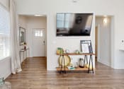 Thumbnail 8 of 40 - a living room with a tv on the wall and a wooden floor at The Cottages at Old Monrovia Apartment , Huntsville, 35806