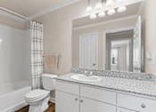 Thumbnail 11 of 36 - A bathroom with a white toilet, sink, and bathtub.