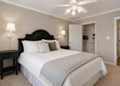 Thumbnail 7 of 36 - A bedroom with a large bed and a ceiling fan.