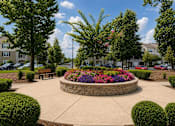 Thumbnail 35 of 36 - A circular garden with a bench in the middle of a courtyard.