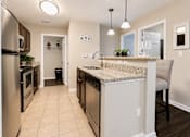 Thumbnail 3 of 36 - A kitchen with a granite counter top and stainless steel appliances.