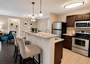 Thumbnail 1 of 36 - A kitchen with a white island and brown cabinets.