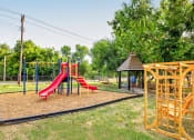 Thumbnail 22 of 29 - a playground at a park with a red slide at Diamond  Trail Apartments, Oklahoma