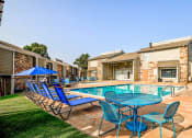Thumbnail 19 of 29 - our apartments have a resort style pool with blue chairs and tables at Diamond  Trail Apartments, Oklahoma, 73112