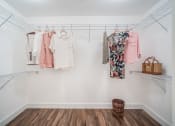 Thumbnail 17 of 35 - a walk in closet with a rack of clothes and a basket on the floor at The Lotus at Village Walk, Fort Myers, 33966