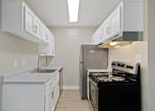 Thumbnail 8 of 20 - Kitchen with white cabinets and a black stove and refrigerator at Elevation Apartments, AZ, 85718