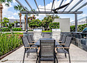 Thumbnail 22 of 22 - A patio with a table and chairs under a roof.