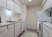 Thumbnail 17 of 22 - A kitchen with white cabinets and a sink.