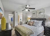 Thumbnail 25 of 32 - A bedroom with a large bed and a ceiling fan.