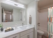 Thumbnail 20 of 20 - A bathroom with a white sink and a mirror above it.