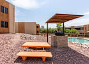 Thumbnail 11 of 20 - A picnic table is in front of a building with a pool at Elevation Apartments, AZ, 85718