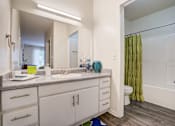 Thumbnail 21 of 21 - A bathroom with a white vanity and a green shower curtain.at Metro 5514, Texas