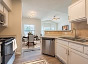 Thumbnail 2 of 15 - A kitchen with a dining table and chairs in the middle of the room.