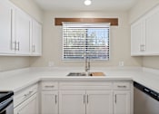 Thumbnail 2 of 25 - A kitchen with white cabinets and a window with blinds.at San Xavier Casitas, Tucson, AZ 85716