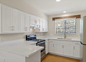 Thumbnail 23 of 25 - A kitchen with white cabinets and a stove top oven at San Xavier Casitas, Tucson