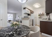 Thumbnail 9 of 26 - A kitchen with a marble table and a fridge.