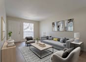 Thumbnail 4 of 26 - A living room with a grey couch, a grey armchair, a coffee table, a lamp, and two paintings on the wall.