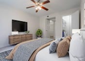 Thumbnail 17 of 26 - A bedroom with a bed, pillows, a ceiling fan, and a television on a wooden cabinet.