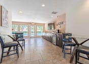 Thumbnail 19 of 26 - A kitchen with a tile floor and a dining table with chairs.