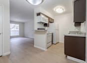 Thumbnail 15 of 26 - A kitchen with white appliances and brown cabinets.