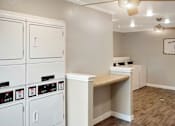 Thumbnail 17 of 17 - A laundry room with washers and dryers.