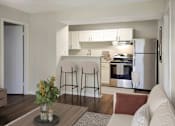 Thumbnail 14 of 17 - A modern kitchen with a refrigerator, stove, and bar stools.