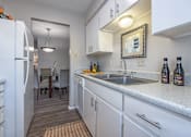 Thumbnail 3 of 14 - Kitchen with white cabinets and a stainless steel sink  at Willow Oaks, Texas, 77802