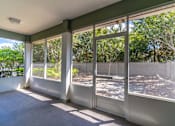 Thumbnail 12 of 15 - an enclosed porch with large windows overlooking a yard and trees