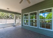 Thumbnail 9 of 15 - a covered porch with sliding glass doors and a patio
