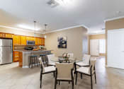 Thumbnail 4 of 15 - a dining room and kitchen with a table and chairs