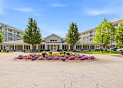 Thumbnail 65 of 87 - A large building with a flower bed in front of it.